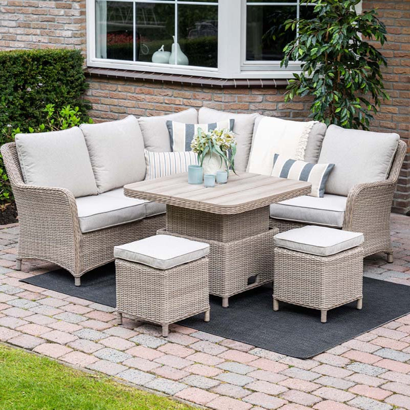 Outdoor patio set with wicker furniture and cushions on a paved patio.