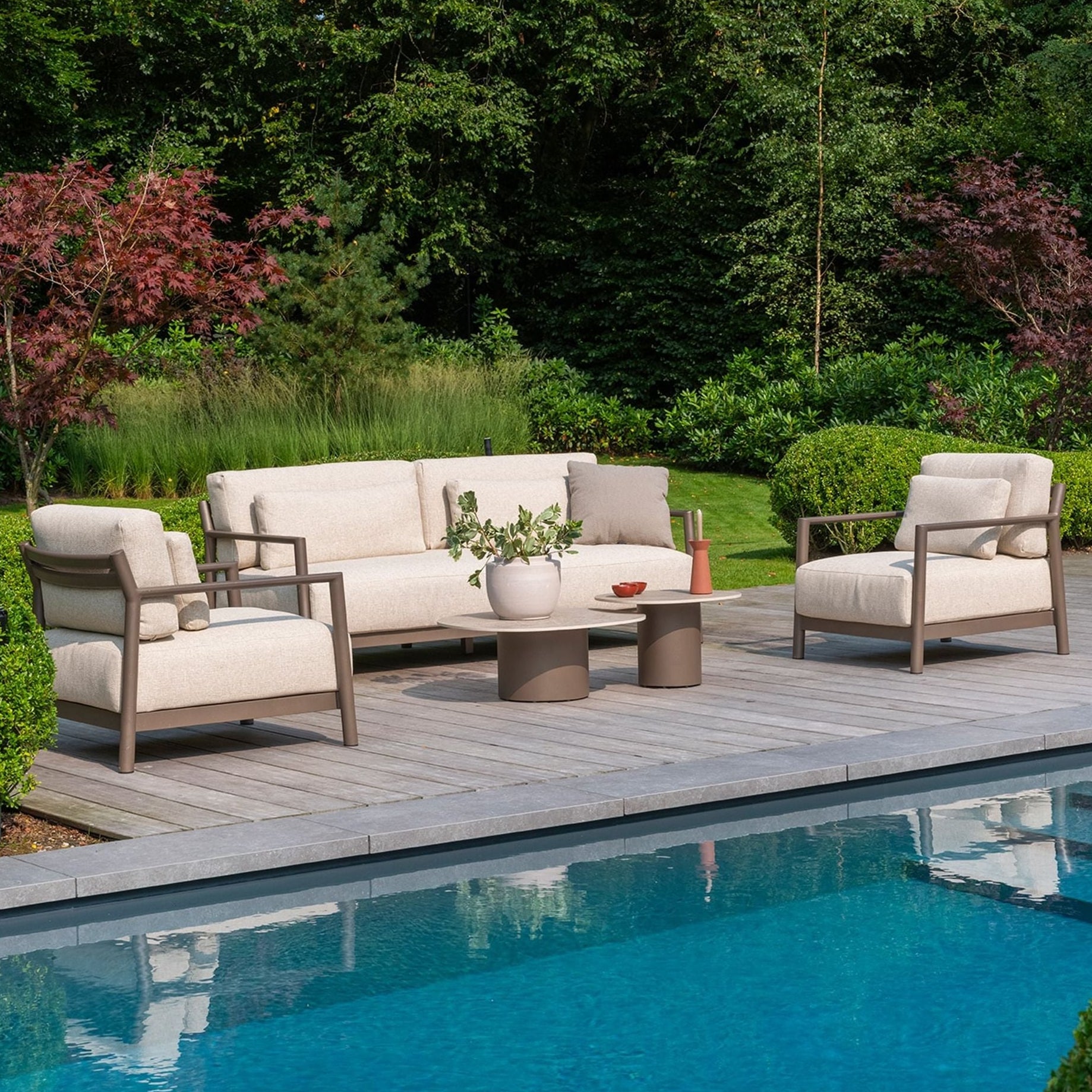 Outdoor patio set with beige cushions by a pool
