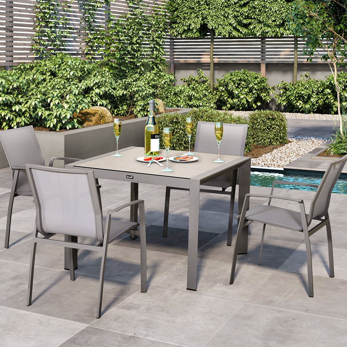 Outdoor patio set with table and chairs near a pool