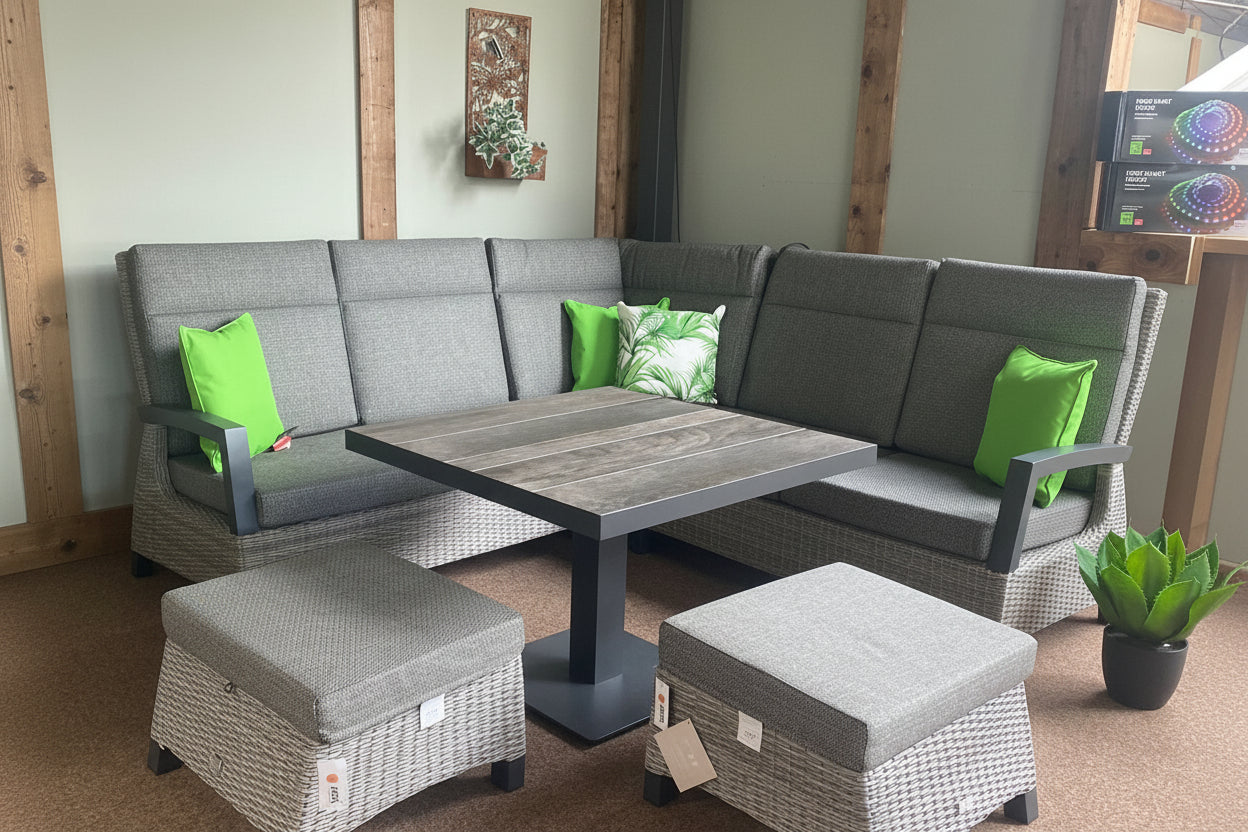 Gray sectional sofa with green pillows and matching ottomans in a room setting.