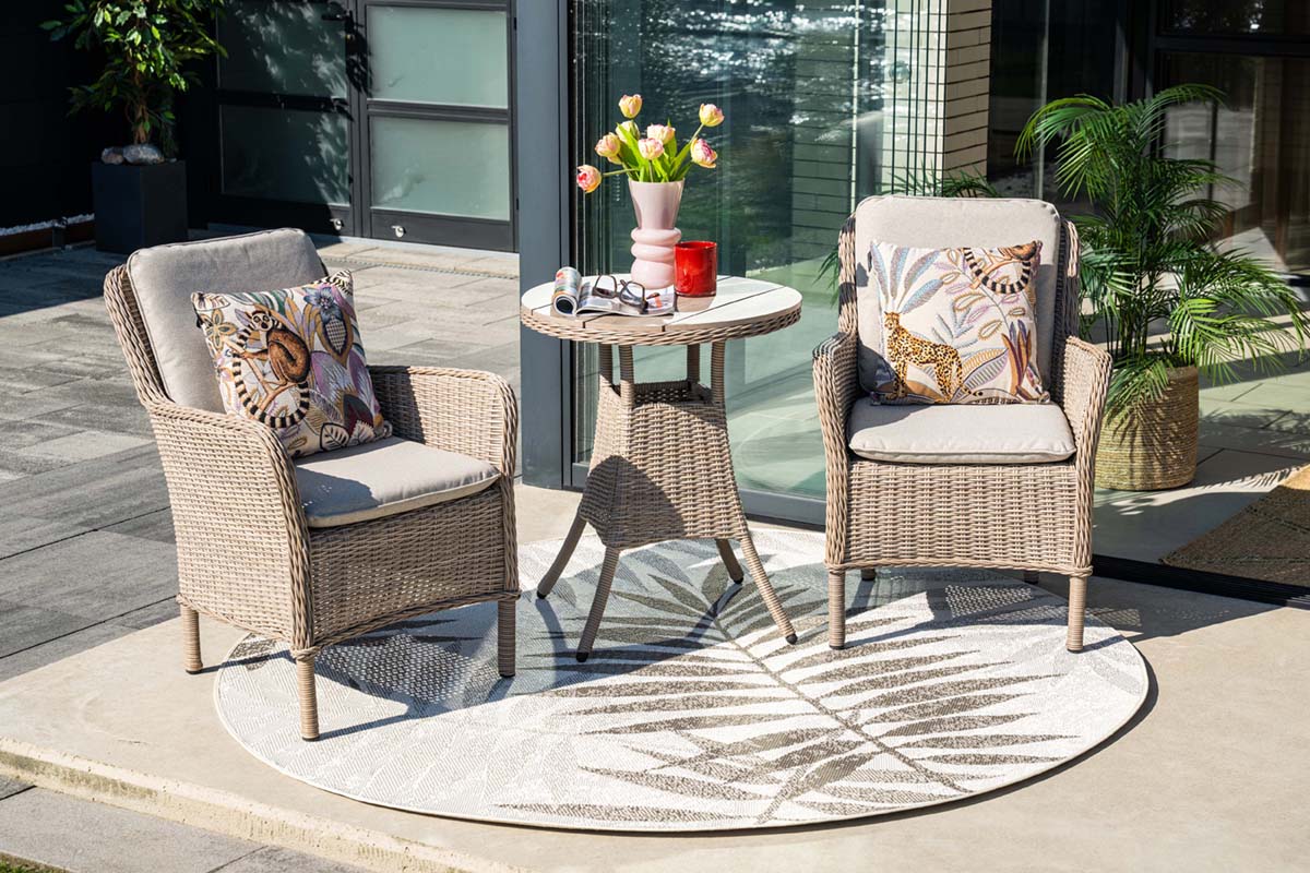 Outdoor patio set with two chairs and a small table on a patio.