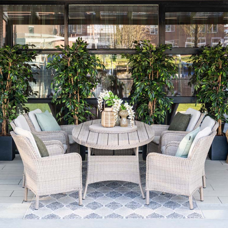 Outdoor patio set with wicker furniture and plants in a modern setting.