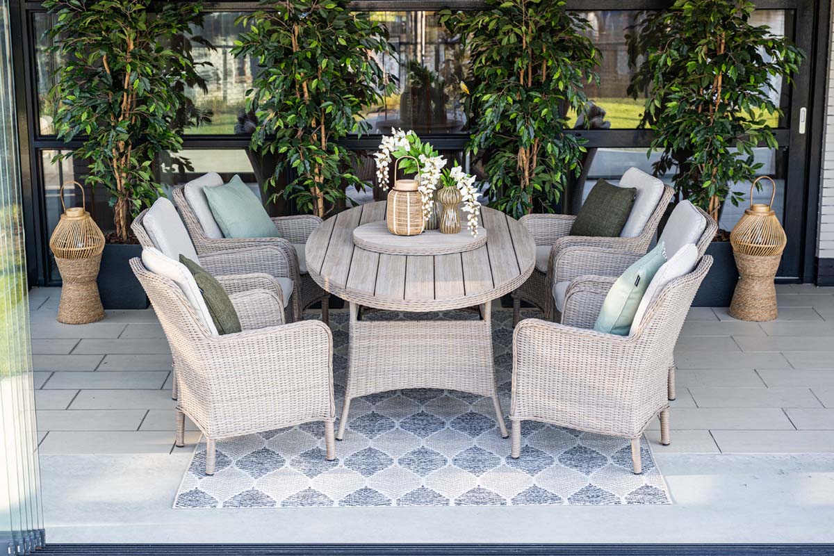 Outdoor patio set with round table and chairs on a tiled patio