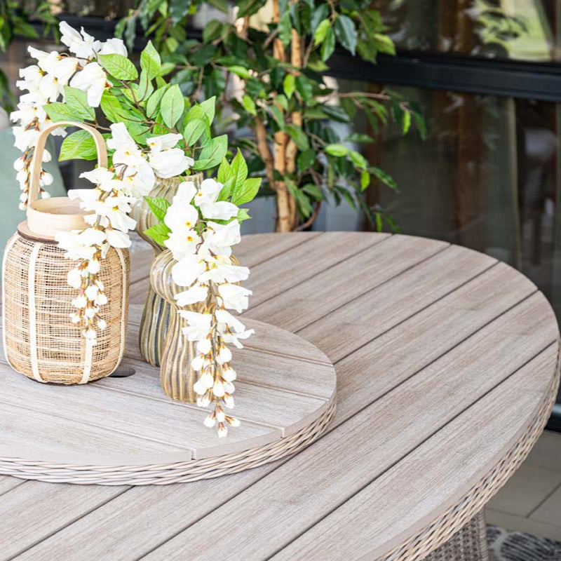 Decorative table setting with wicker baskets and white flowers on a wooden table.