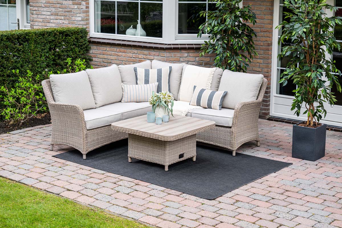 Outdoor patio set with wicker furniture on a paved patio area.