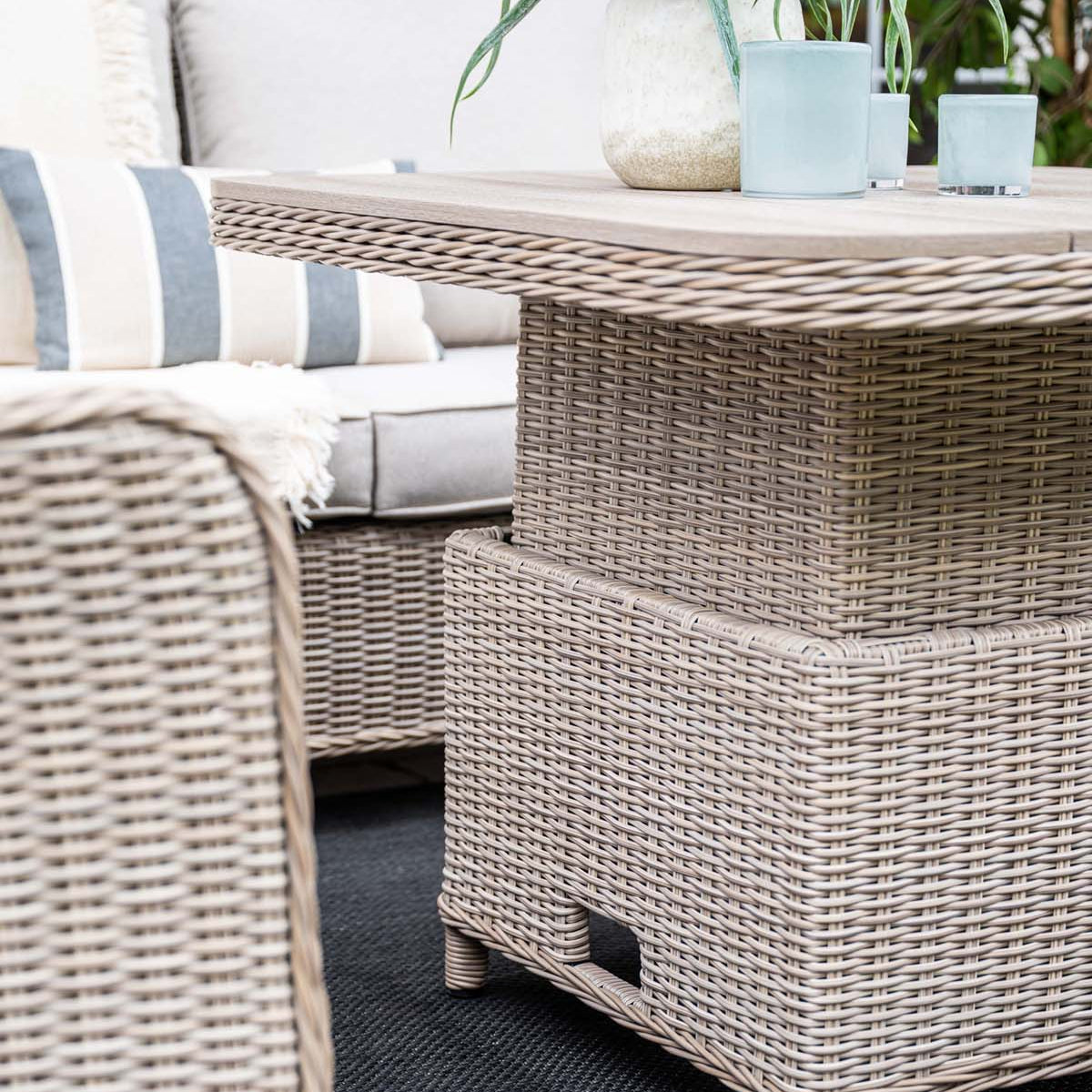 Wicker outdoor furniture set with a table and chairs on a patio.