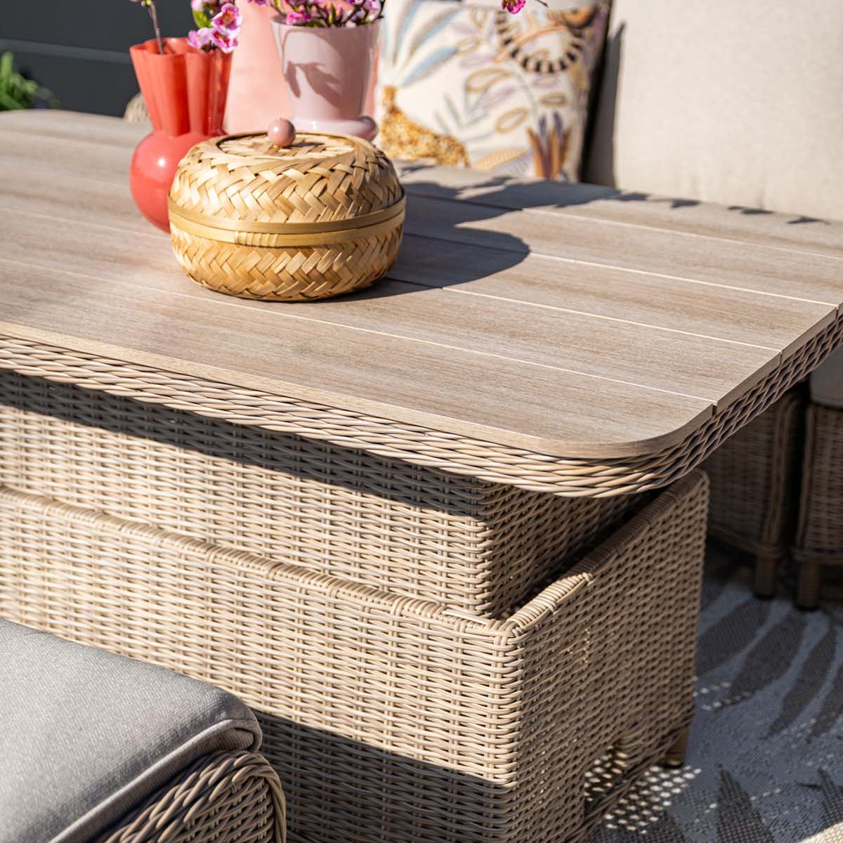 Wicker coffee table with decorative items on a patio setting
