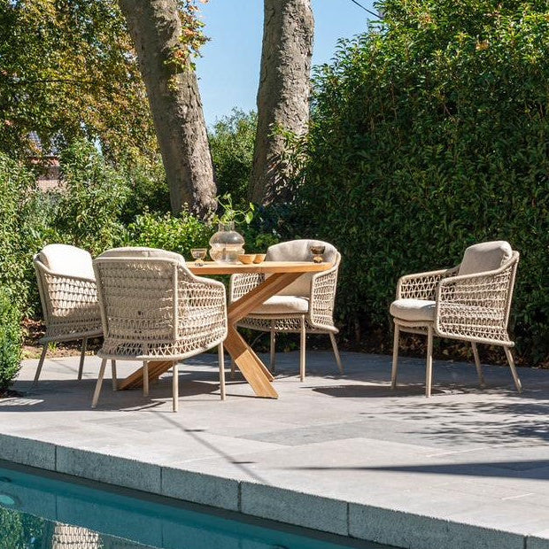 Outdoor patio set with table and chairs by a pool