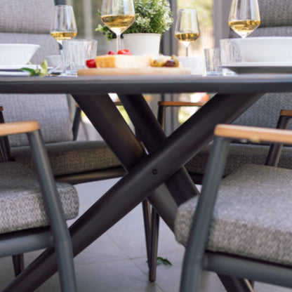 Outdoor dining setup with table, chairs, and wine glasses on a patio.