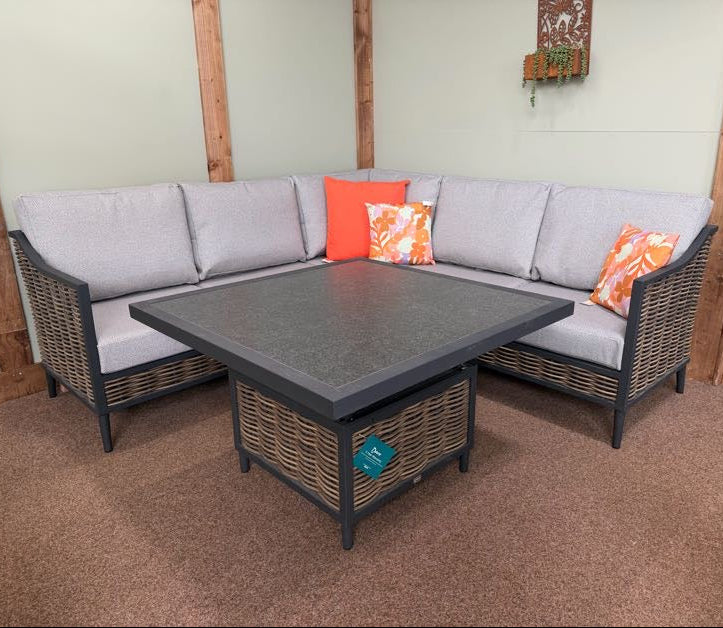 Outdoor patio furniture set with a sectional sofa and table on a carpeted floor.